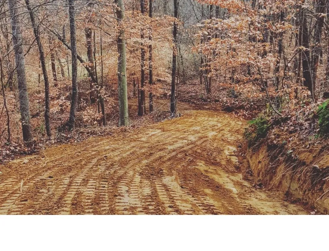 Compact track loader grading and leveling ground